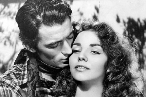 a man embraces a woman while kissing her cheek